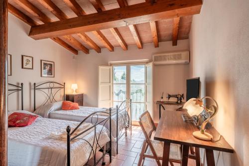 1 dormitorio con 2 camas, escritorio y mesa en Appartamento La Terrazza, en Porcari
