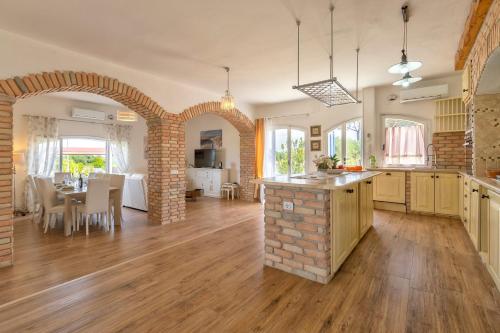 an open kitchen and dining room with a brick archway at Villa Sara in Sorso