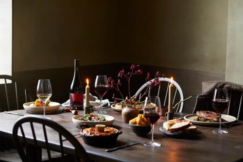a table with plates of food and glasses of wine at The Penny Bun in Otley