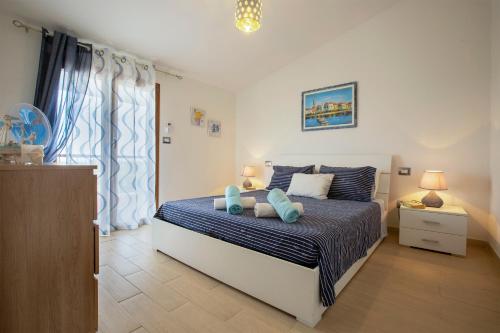 a bedroom with a bed with blue pillows at Villa Felicità in Sorso