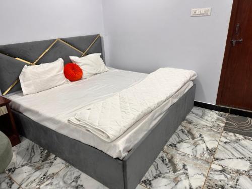 1 cama con 2 almohadas rojas en una habitación en Garden Villa hotel, en Ujjain