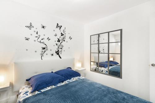 a bedroom with a bed with blue pillows and a mirror at Bungalow Josephin in Patalavaca