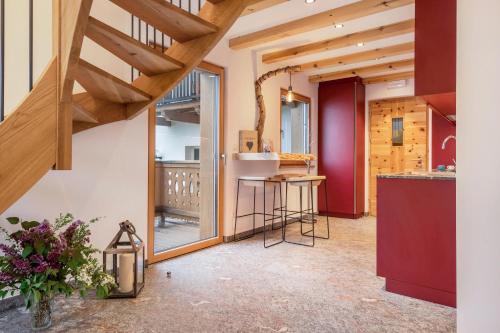 an open kitchen with wooden ceilings and a staircase at Grotthof in Nova Ponente
