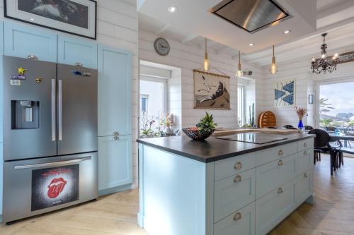 La cuisine est équipée d'un réfrigérateur et d'un évier. dans l'établissement Villa les Bleuets - proche Océan, à Clohars-Carnoët