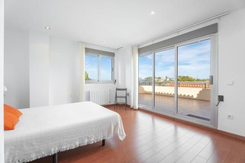 Luxury villa with swimmingpool في Alginet: غرفة نوم بيضاء مع سرير ونافذة كبيرة