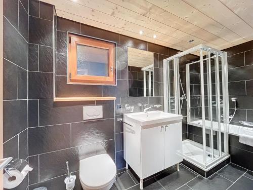 een badkamer met een toilet, een wastafel en een spiegel bij Fouquet Apartments in Verbier