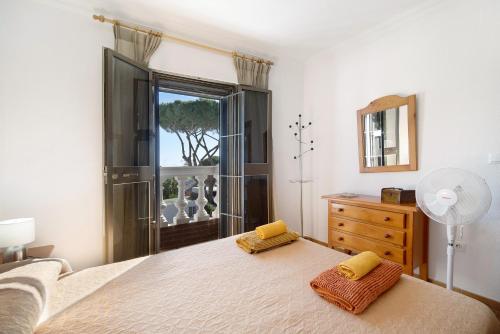 a bedroom with a bed and a dresser and a window at El Chozo in Chiclana de la Frontera