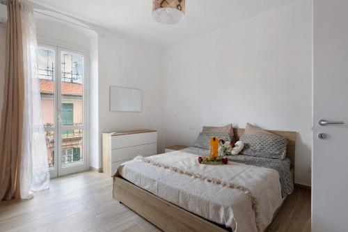 Un dormitorio blanco con una cama y una ventana. en Maestrale, en La Spezia