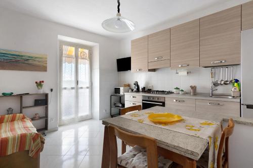 a kitchen with a table and chairs and a kitchen with white cabinets at Da Ercolino in Pitelli