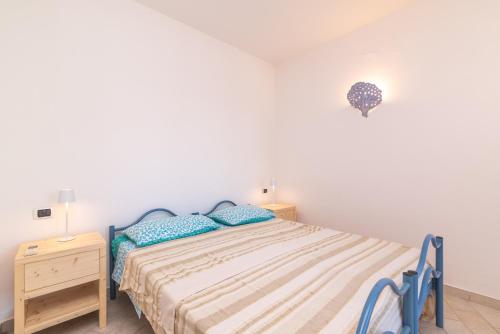 Habitación blanca con cama y mesita de noche en I Mirti, en Porto Pozzo