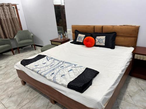Una cama con una bola de naranja encima. en Garden Villa hotel, en Ujjain