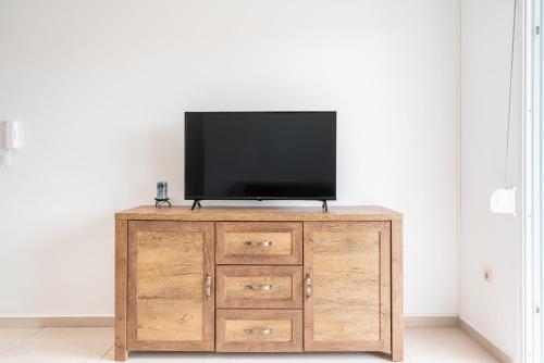a television on top of a wooden cabinet in a room at Ilia's Apartment with view 2 in Asgourou