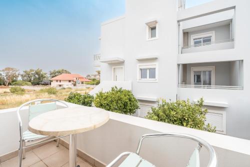 a balcony with a white table and chairs at Ilia's Apartment with view 2 in Asgourou