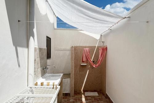 a white bathroom with a sink and a shower at Vento Di Mare in Torre Lapillo