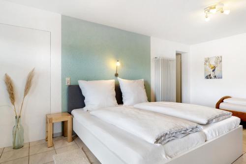 - une chambre avec un grand lit blanc et des oreillers blancs dans l'établissement Ferienwohnung Faisst, à Kappel-Grafenhausen
