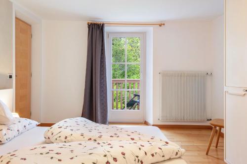 a bedroom with two beds and a window at Grotthof in Nova Ponente