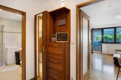a hallway with a wooden cabinet and a living room at Ferienwohnung am Bodensee in Bregenz