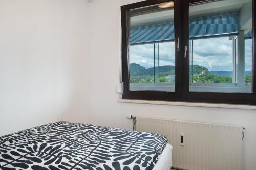a bedroom with a bed and a window with mountains at Ferienwohnung am Bodensee in Bregenz
