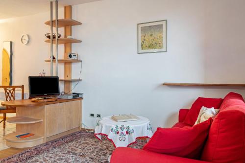 a living room with a red couch and a tv at Grotthof in Nova Ponente