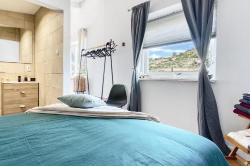 Un dormitorio con una cama azul y una ventana en La Luna en Jijona