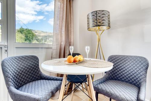 a dining room with two chairs and a table with fruit on it at La Luna in Jijona