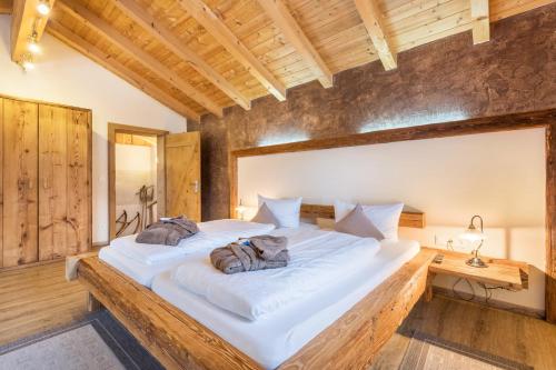duże białe łóżko w pokoju z drewnianymi ścianami w obiekcie Ferienwohnung Stub´n w mieście Freyung