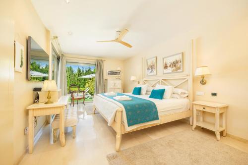 een slaapkamer met een bed, een bureau en een raam bij Bellviure Luxury Villa in Marratxí 