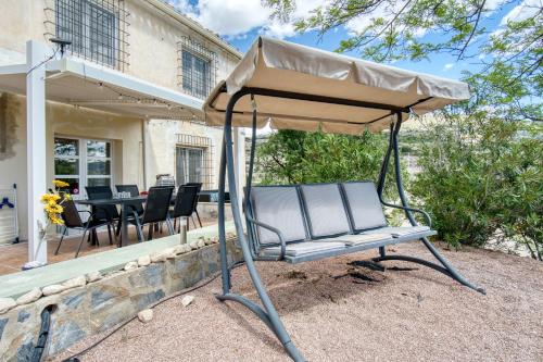 a swinging chair under an umbrella on a patio at Casa en Finca Rustica in Jijona