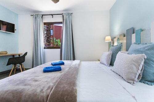 een slaapkamer met een groot bed met blauwe kussens erop bij Casa Desierto Azul in Corralejo