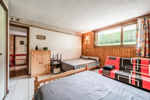 a bedroom with two beds and a couch in it at Appartement en residence in Morzine