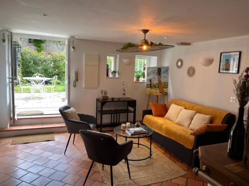 un salon avec un canapé, des chaises et une table dans l'établissement L'Atelier d'Olga - Homillesime, à Dijon