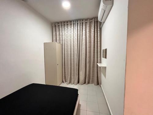 a small room with a black bed and a window at Homestay Bandar Mahkota Banting in Banting