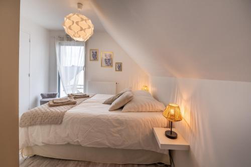 um quarto com uma cama e uma mesa com um candeeiro em Villa West Attitude em Erdeven