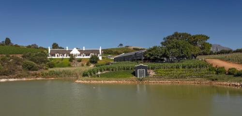 an island in the middle of a river with a house at Aaldering Luxury Lodges in Stellenbosch