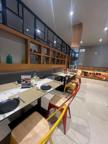 a dining room with long tables and chairs at Sparrow Hotel Managed by Siara Sariska Alwar in Alwar