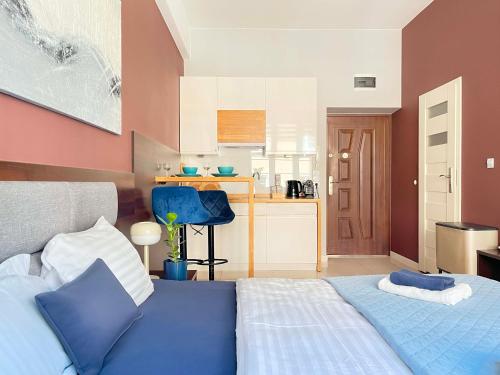 a bedroom with a blue bed and a kitchen at Well-connected Apartment in Old Town Cracow in Krakow
