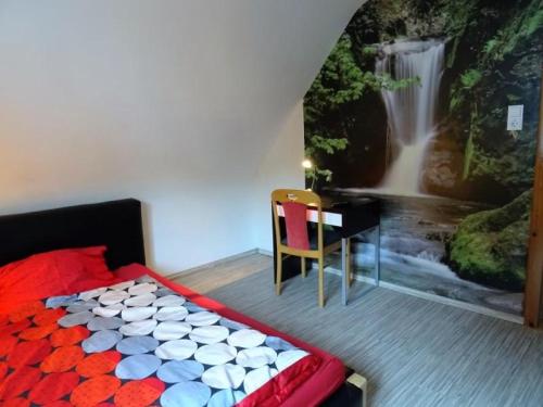 a bedroom with a painting of a waterfall on the wall at Ferienwohnung Burgblick in Hausach