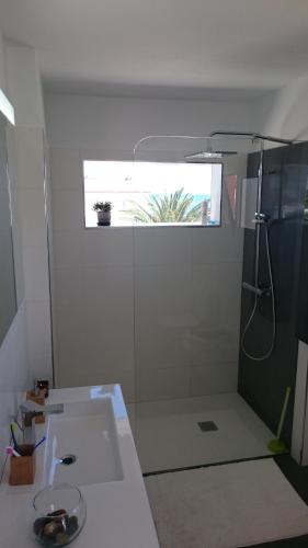 a bathroom with a sink and a shower with a window at Corralejo beach life in La Oliva