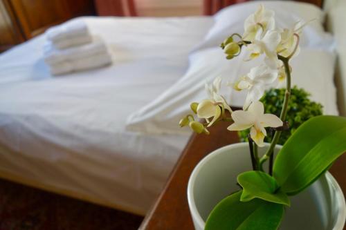 un vase avec des fleurs blanches sur une table à côté d'un lit dans l'établissement 55 m2 apartment very quiet close to the Eiffel Tower, à Paris