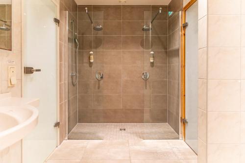 een douche met een glazen deur in de badkamer bij Landhaus Morgensünn in Ahrenshoop