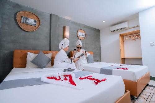 un grupo de 3 personas en una habitación con 2 camas en Grand Elevation Hotel, en Phnom Penh