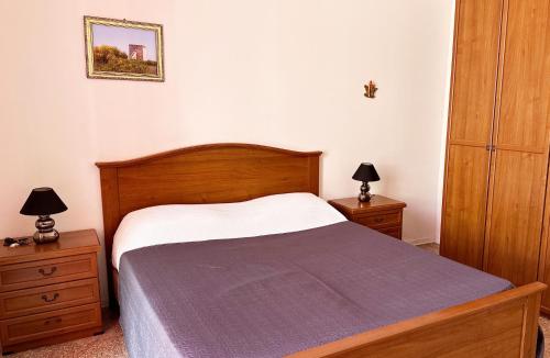 a bedroom with a bed and two dressers and two lamps at Vento Di Mare in Torre Lapillo