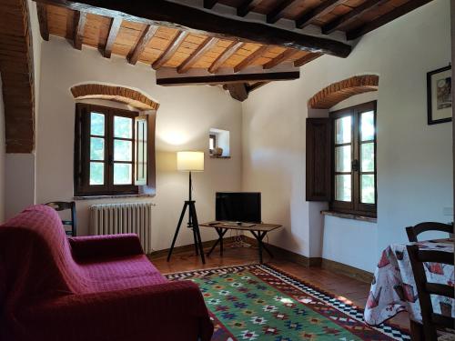 a living room with a couch and a table and windows at Villa La Nussa in Capolona