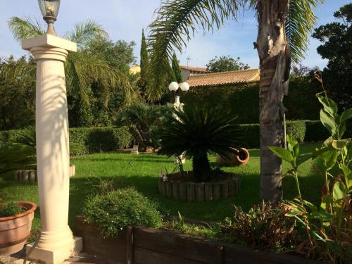 a lamp post in a garden with a palm tree at Hotel Iris La Eliana in La Eliana