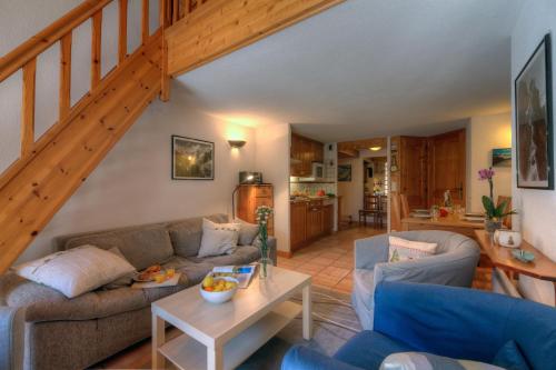 - un salon avec deux canapés et un escalier dans l'établissement Résidence Le Cristal - Grands Montets 21 - Happy Rentals, à Chamonix-Mont-Blanc