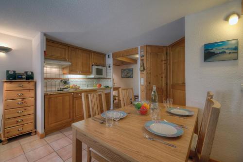 une cuisine avec une table en bois et des plaques de cuisson. dans l'établissement Résidence Le Cristal - Grands Montets 21 - Happy Rentals, à Chamonix-Mont-Blanc
