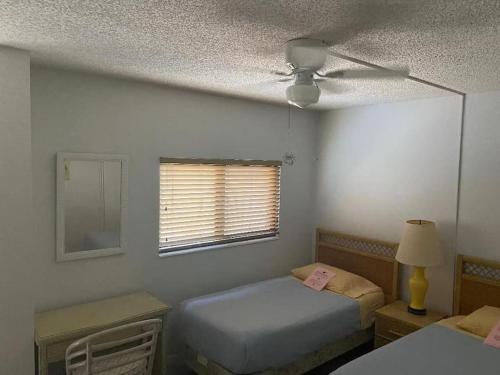 a bedroom with two beds and a ceiling fan at Oceanfront retreat, serene views & screened lanai #30 in Marathon