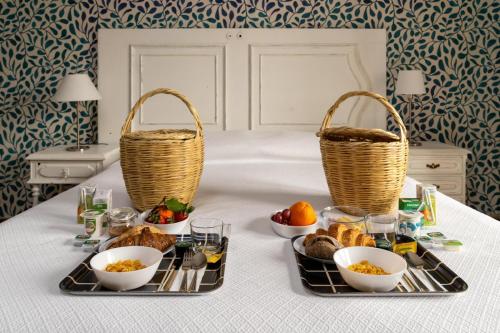 Una bandeja de desayuno con pan y cestas sobre una cama. en DOME Alvares Cabral, en Lisboa