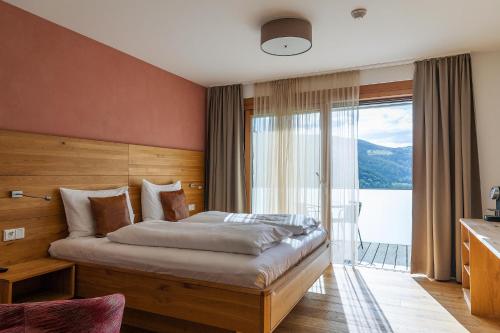 a bedroom with a large bed with a large window at Buchberg38 in Buchberg bei Herberstein