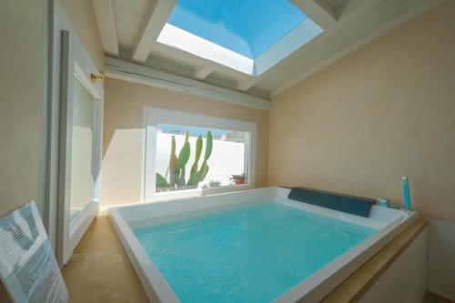 - une grande piscine dans une chambre avec fenêtre dans l'établissement Pascaraymondo Suite Palace, à Gallipoli